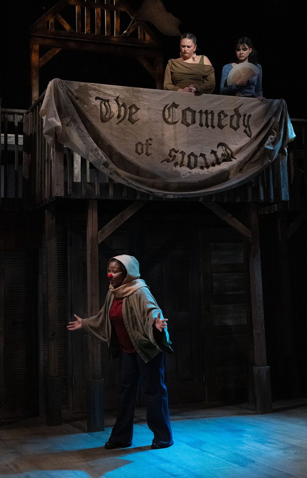 A single figure in a pool of blue light beneath the banner