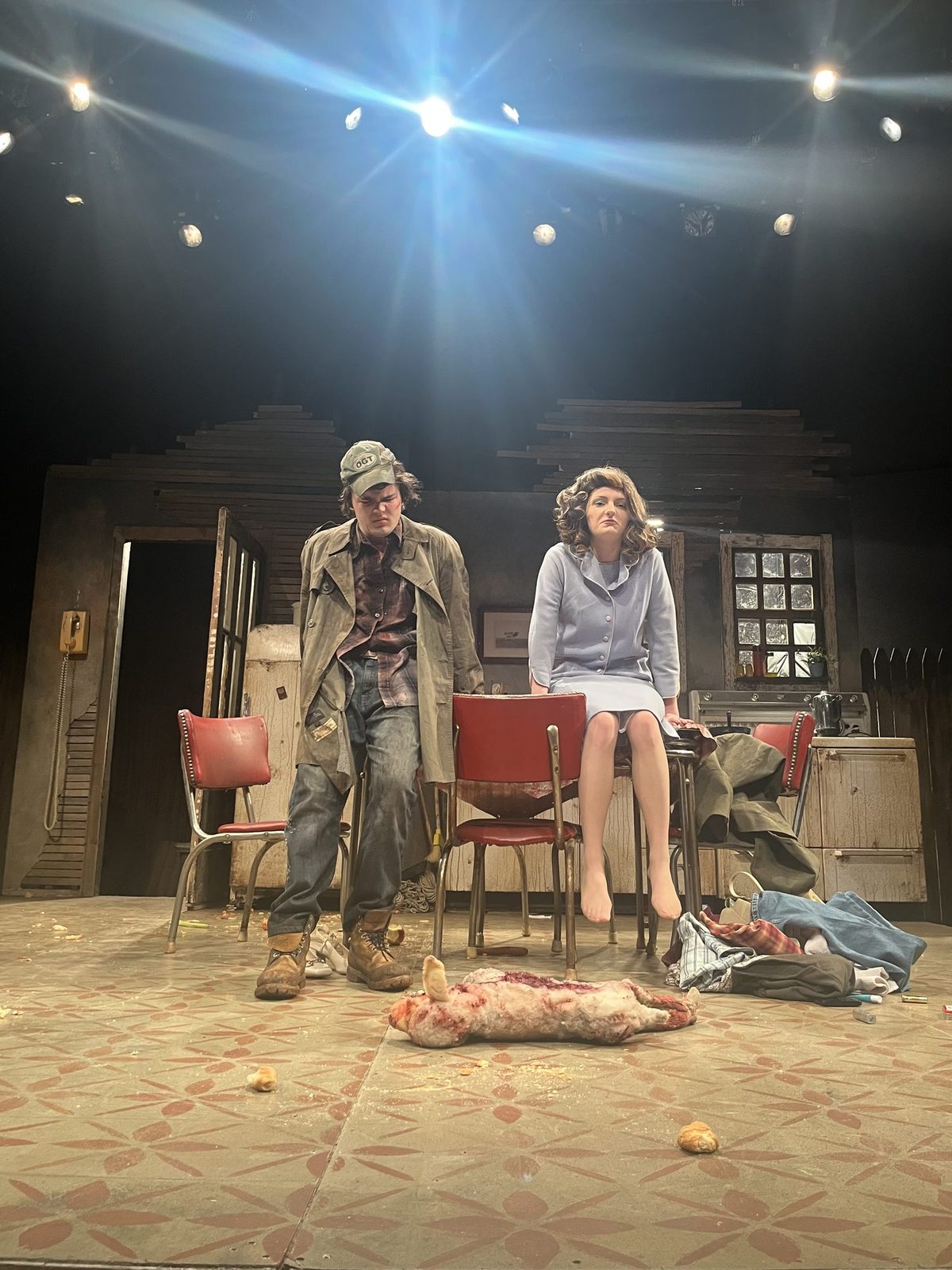 Two characters on the finished kitchen set, the lamb carcass downstage