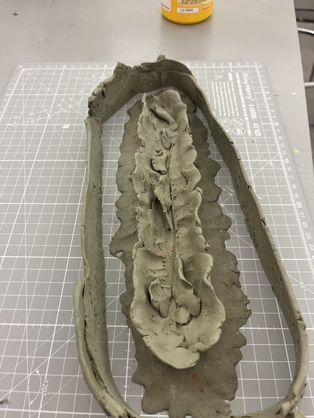 A clay form sculpted on a cutting mat as the mould for the carcass
