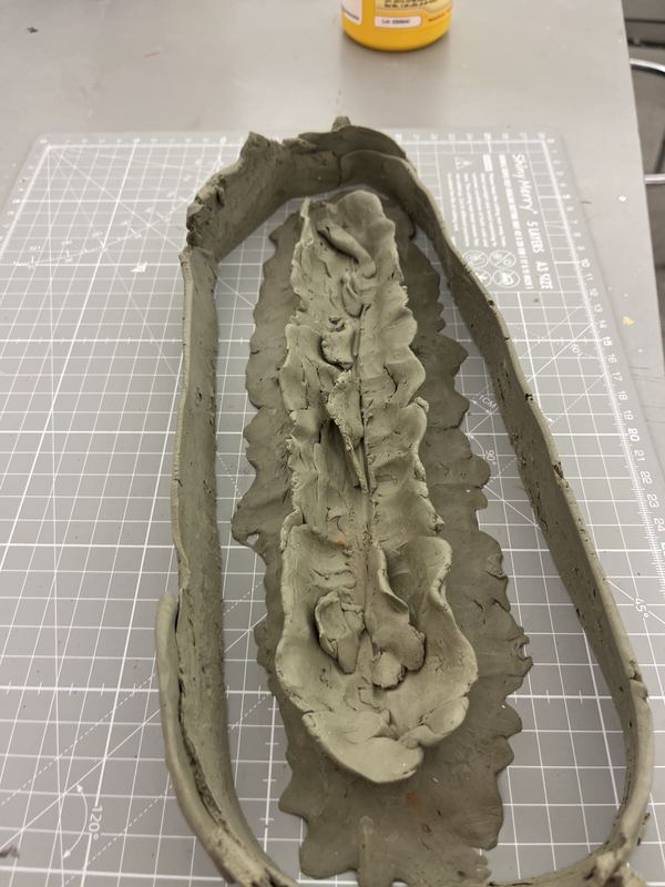 A clay form sculpted on a cutting mat as the mold for the carcass