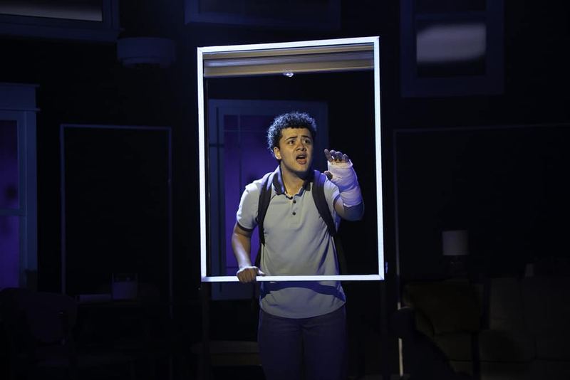A figure lit through a suspended window frame in Dear Evan Hansen