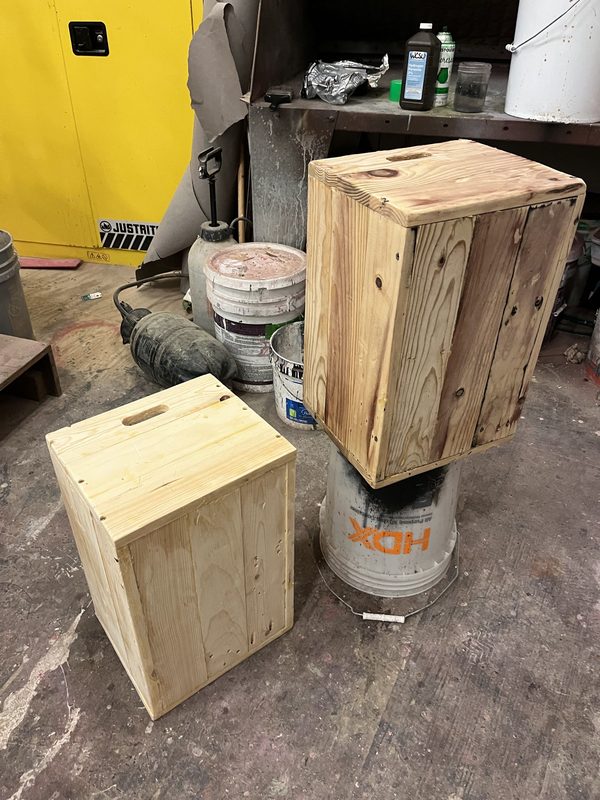 Two crates built up and sitting on buckets in the scene shop