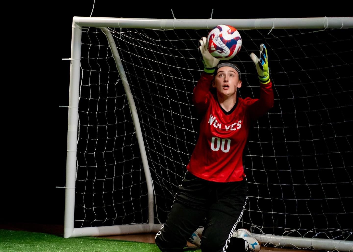A player alone in goal under a cool wash